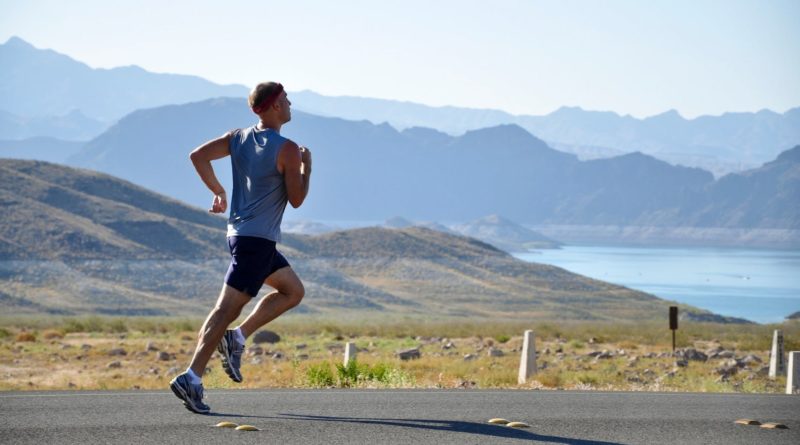 man running on side of road